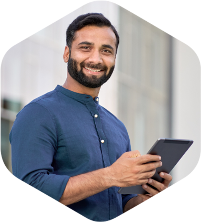 A man happily using a tablet computer while enjoying the outdoors.