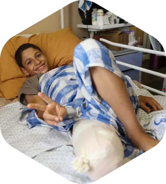 A boy lying in a hospital bed with a cast on his leg, receiving medical care and treatment.
